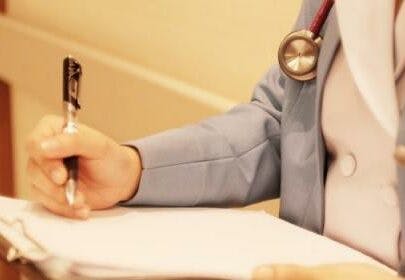 Close-up of a medical expert writing at work